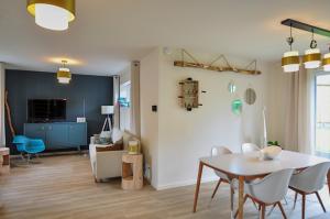 a dining room and living room with a table and chairs at Le sourire - Maison avec Jardin, Bureau & BBQ in Rochefort