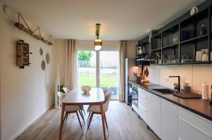a kitchen and dining room with a table and chairs at Le sourire - Maison avec Jardin, Bureau & BBQ in Rochefort