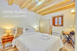 a bedroom with a bed with towels on it at Hotel LASCASAS& ARTE in Medinaceli
