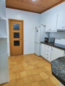 a kitchen with white cabinets and a wooden door at Apart Granollers Centre in Granollers +18 photos