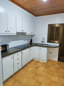 a kitchen with white cabinets and a counter top at Apart Granollers Centre in Granollers