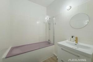 a bathroom with a tub and a sink and a mirror at Flexliving - room - Lindet in Paris +1 photo