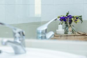- un comptoir de salle de bains avec un vase de fleurs et un lavabo dans l'établissement Hotel Rural Estación de la Dehesa, à Almazán 74 autres photos