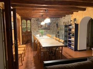 a dining room with a long table and chairs at Casa Rural El Pati de l´Albera in Sant Climent Sescebes