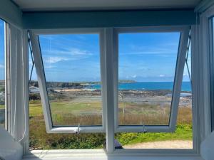 ein Fenster in einem Haus mit Meerblick in der Unterkunft The Moorings - Just a few metres from the sea! in Padstow