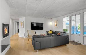 Una sala de estar con un sofá y un televisor en Lovely Home In Ulfborg With Sauna, en Ulfborg