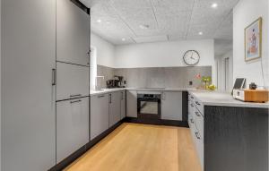 Una cocina con gabinetes blancos y un reloj en el techo. en Lovely Home In Ulfborg With Sauna, en Ulfborg 22 fotos más