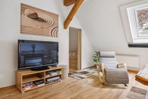 a living room with a television and a chair at Ferienwohnung in Kramerhof mit Grill und Garten in Kramerhof