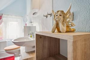 a statue of a girl sitting on a counter in a bathroom at Ferienwohnung in Kramerhof mit Grill und Garten in Kramerhof +12 photos