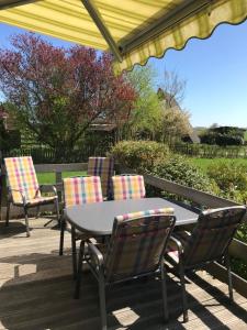 a patio with a table and chairs on a deck at Ferienhaus in Fedderwardersiel mit Terrasse in Butjadingen