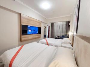 Postel nebo postele na pokoji v ubytování Yilong Yitang Hotel Kunming Railway Station Joy City Center