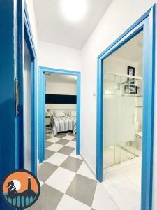 a hallway with a blue door and a checkered floor at Cala Micaela by Bossh! Apartments in Chipiona