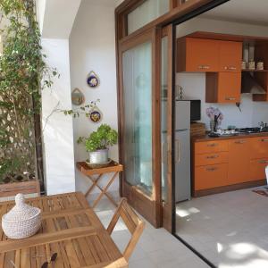 cocina con armarios naranjas y mesa en il faretto casale grandangolo, en Capoliveri