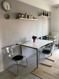 a table and chairs in a room with a clock at Seaside Christina Apartments in Ierissos