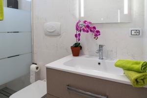 a bathroom with a sink and a toilet and a plant at Casa Vacanza Mario 1A a 180 mt dal mare di Punta Prosciutto in Punta Prosciutto +9 photos