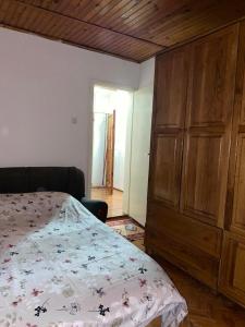 a bedroom with a bed and a wooden cabinet at Sunlit City Apartment Gjakova in Gjakove