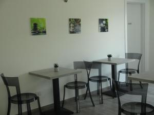 a room with tables and chairs and pictures on the wall at Monte Zucco Relax self check in in San Pellegrino Terme
