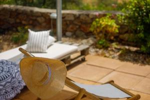 a straw hat sitting on a chair in a yard at La Pietra Maisonettes in Neokhórion +43 photos
