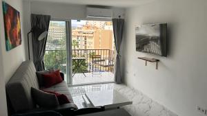 a living room with a couch and a large window at Apartamento costa del sol in Torremolinos