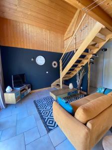 FontenuにあるCharmante maison en bois 8 persのソファと階段のあるリビングルーム