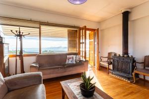 a living room with a couch and a fireplace at Spacious Cottage - Panoramic Sea & Mountain Views in Ano Doloi