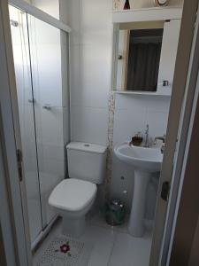 Un baño blanco con inodoro y lavabo. en Portinari 2, en Rio das Ostras