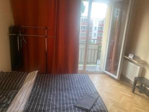 sypialnia z łóżkiem i dużym oknem w obiekcie Warsaw rooms w Warszawie