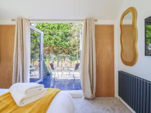 a bedroom with a bed and a sliding glass door at Blackrock Gem in Porthmadog