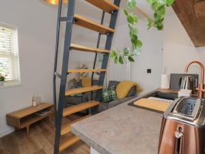 a kitchen with a loft bed in a room at Llofft Penwaig The Herring Loft in Cemaes Bay