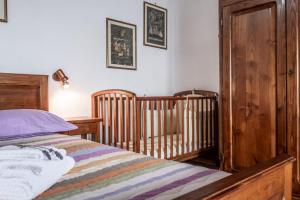 a bedroom with a bed and two cribs at Casaletto della musica in Viterbo