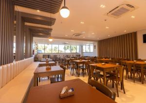 戈亚尼亚Rota 44 Hotel的有木桌椅和窗户的餐厅