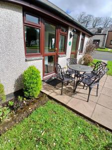 a patio with a table and chairs in front of a house at Tolpedn Cottage in Gulval