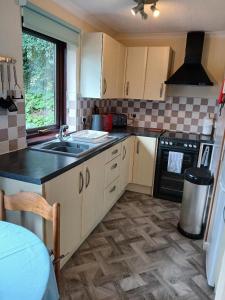 a kitchen with a sink and a stove at Tolpedn Cottage in Gulval +7 photos