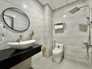 a bathroom with a sink and a toilet and a mirror at LION 5 HOTEL in Can Tho +21 photos