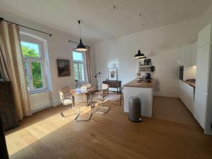 a living room with a table and a kitchen at Beletage Johann Strauss in Klosterneuburg