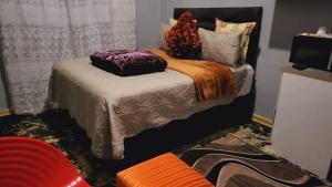 a bedroom with a bed with pillows on it at Golden Gate Guest House in Mahikeng
