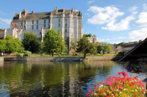 a large white building next to a body of water at Appartement Hyper Centre Cosy avec Balcon in Châteaudun
