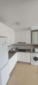 a kitchen with white cabinets and a white refrigerator at EnBURELA Confort y Relax in Burela de Cabo