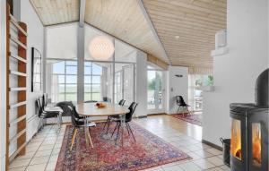 a dining room with a table and chairs and a fireplace at Beautiful Home In Vestervig With Sauna in Vestervig