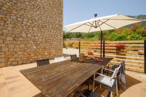 a wooden table with an umbrella on a patio at La Pietra Maisonettes in Neokhórion