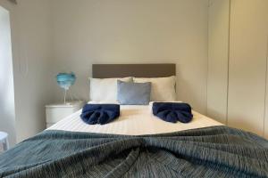 a bedroom with a bed with two blue towels on it at Casa do Mar North in Ponta Delgada