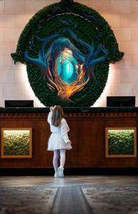 a little girl standing in front of a art exhibit at Dream Castle Hotel Marne La Vallee in Magny-le-Hongre