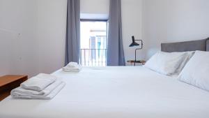 een slaapkamer met een wit bed met handdoeken erop bij EasyTopStay - Piazza Navona Elegant Apartment in Rome