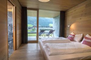 two beds in a room with a balcony at Smaragdresort Top 3.2 Happy Alps in Bramberg am Wildkogel