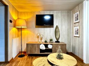 a living room with a table and a tv on a wall at As Carolinas in Isla de Arosa