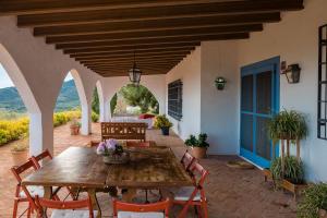 an outdoor patio with a wooden table and chairs at House -Sleeps 8-Natural Pool-Pet Friendly in Artana