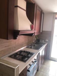 a kitchen with a stove and a sink at Casa Nonna Rosa in Nettuno