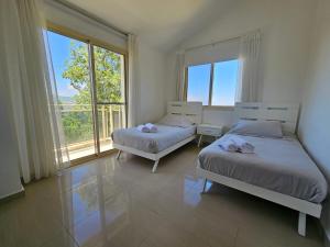 a bedroom with two beds and a large window at Beit Mema in Aḑ Ḑahr +103 photos