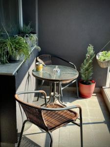 a table and chairs on a patio with plants at Sunny & Comfort Apartment next to Tech Park for 4 Guests in Sofia