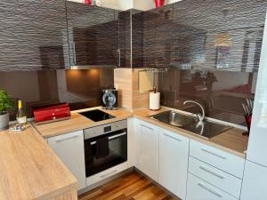 a kitchen with white cabinets and a sink at Sunny & Comfort Apartment next to Tech Park for 4 Guests in Sofia